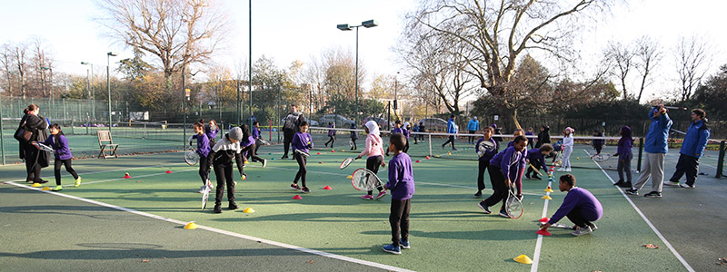 kids taking part in a community tennis session on park tennis courts
