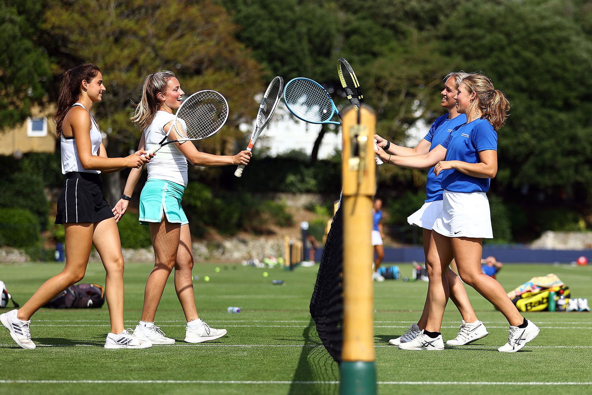 Four female tennis players cheering each other