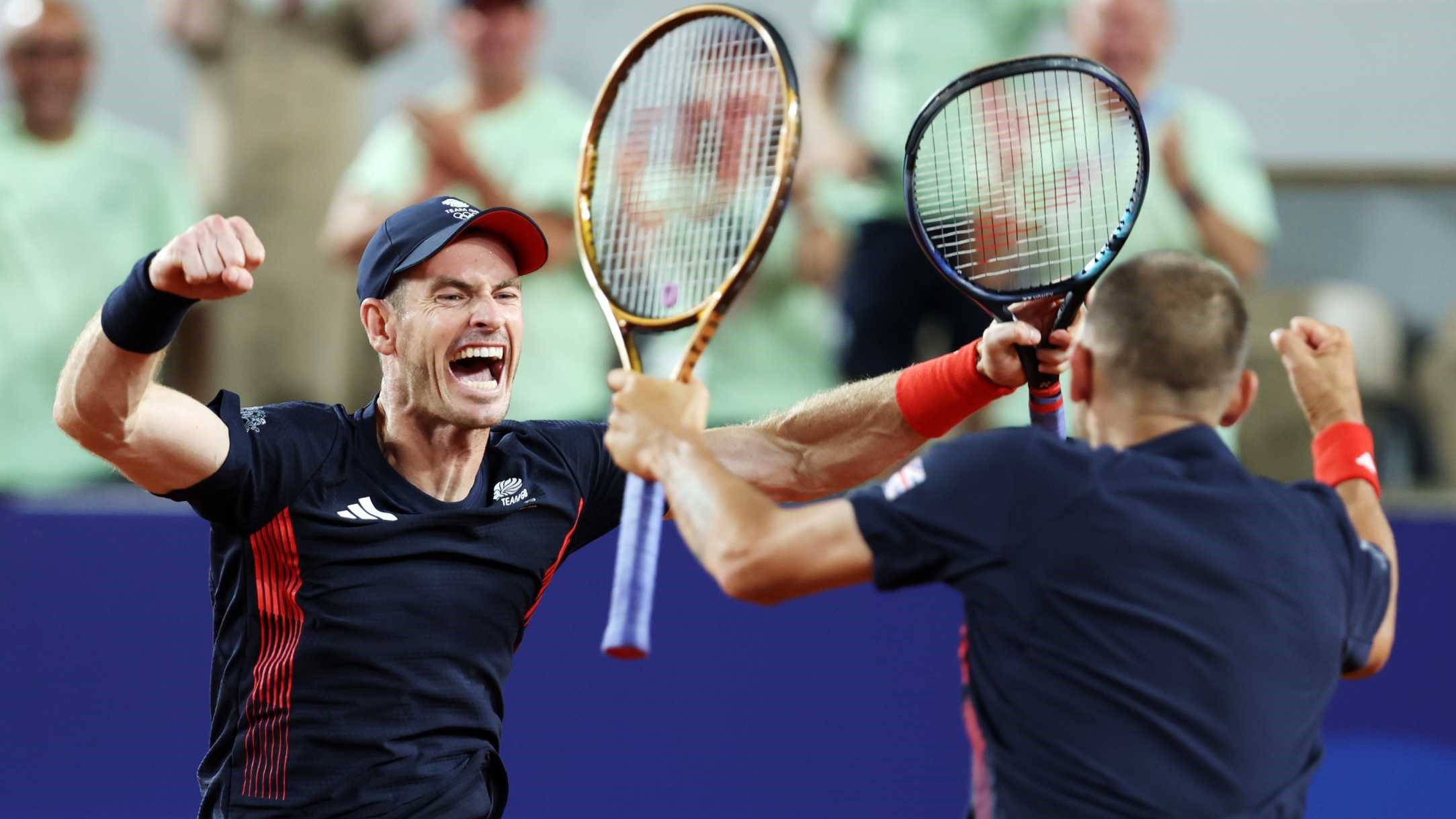 Andy Murray screaming and cheering alongside Dan Evans while holding their tennis rackets