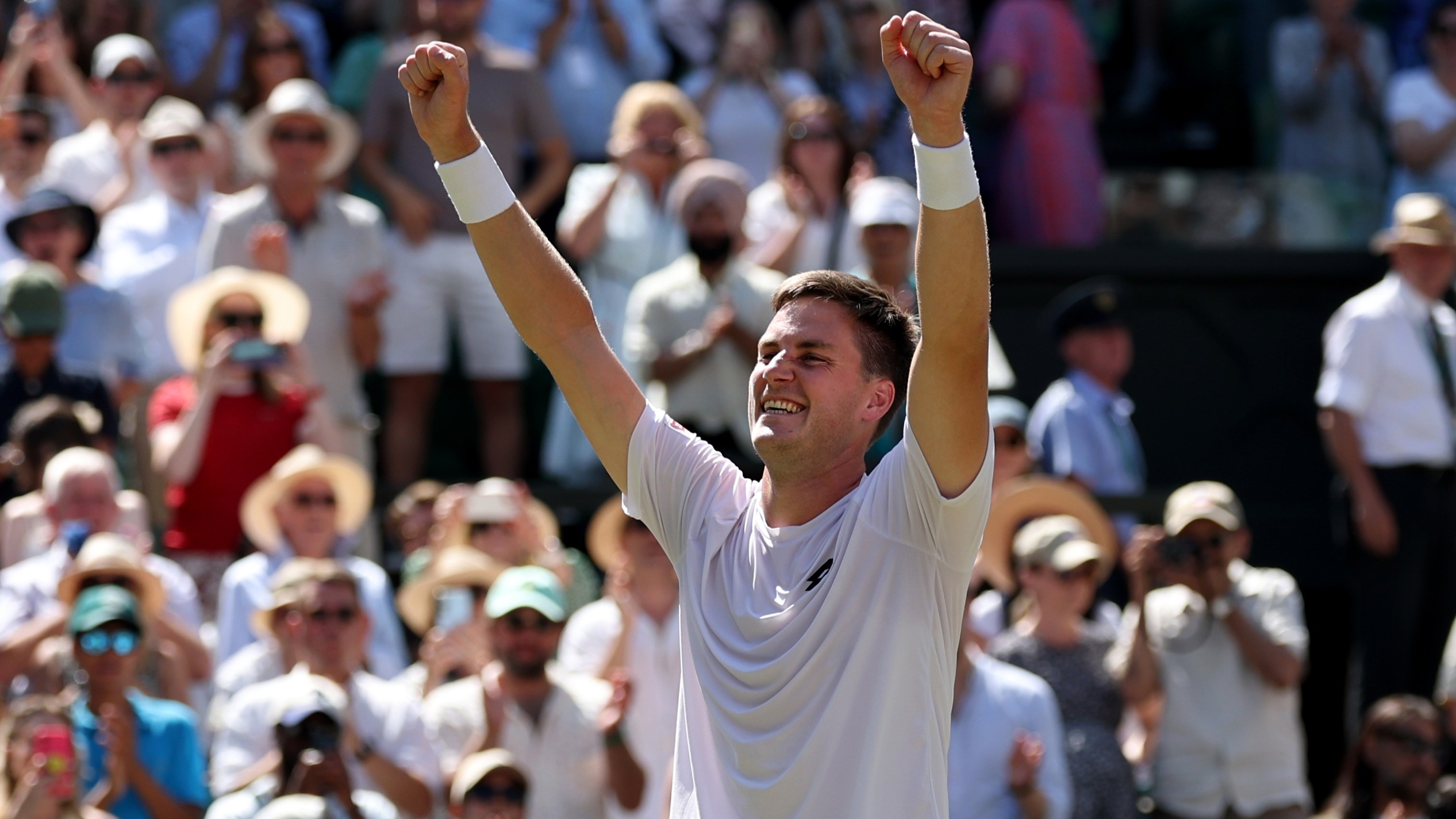 Henry Patten celebrates with both arms in the air after winning his second Wimbledon men's doubles title