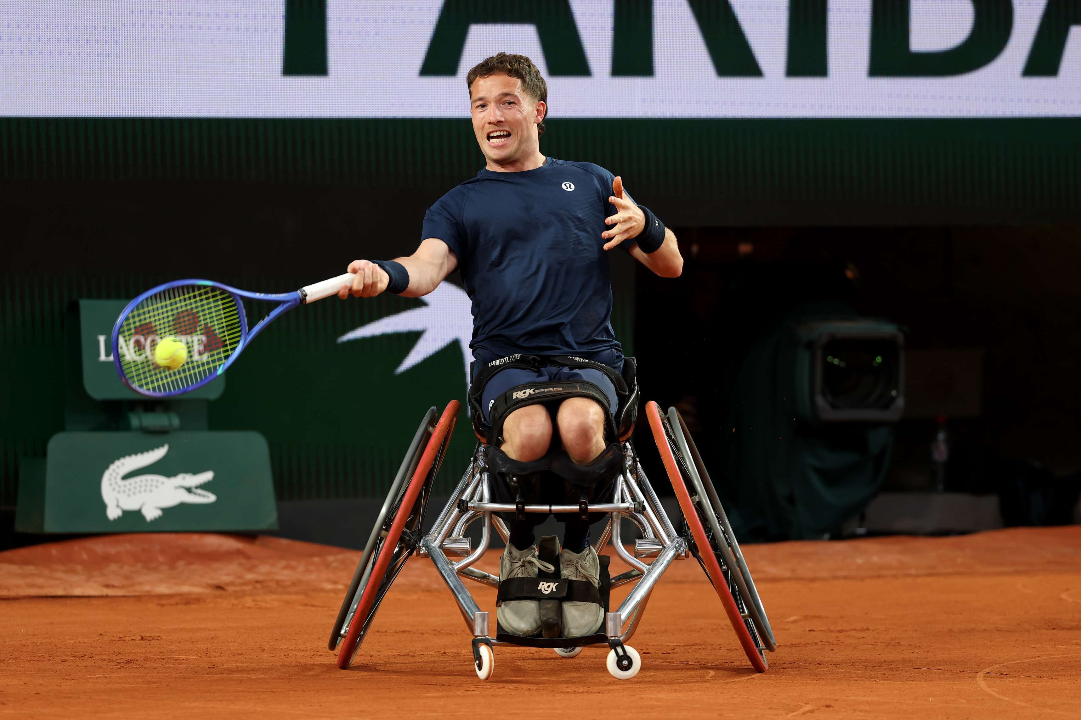 Wheelchair tennis star Alfie Hewett sat in his wheelchair while hitting a tennis ball on a clay court at Roland Garros