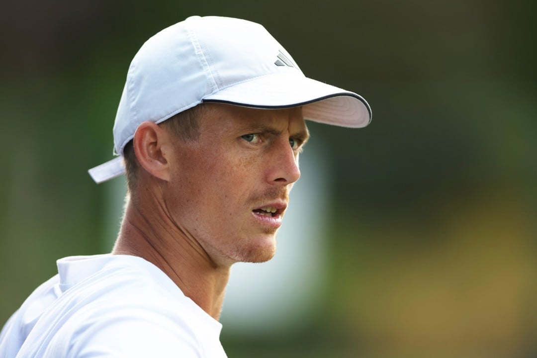 Billy Harris wearing a white top and white hat while looking straight ahead