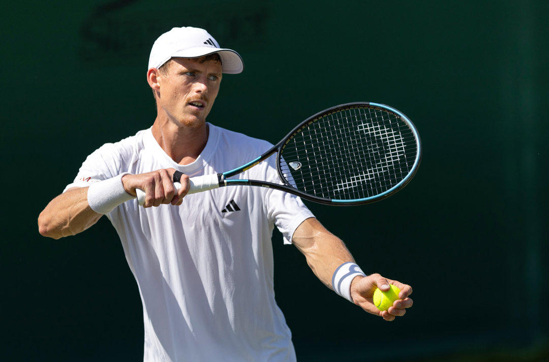 Billy Harris preparing to hit a serve on court at Wimbledon qualifying