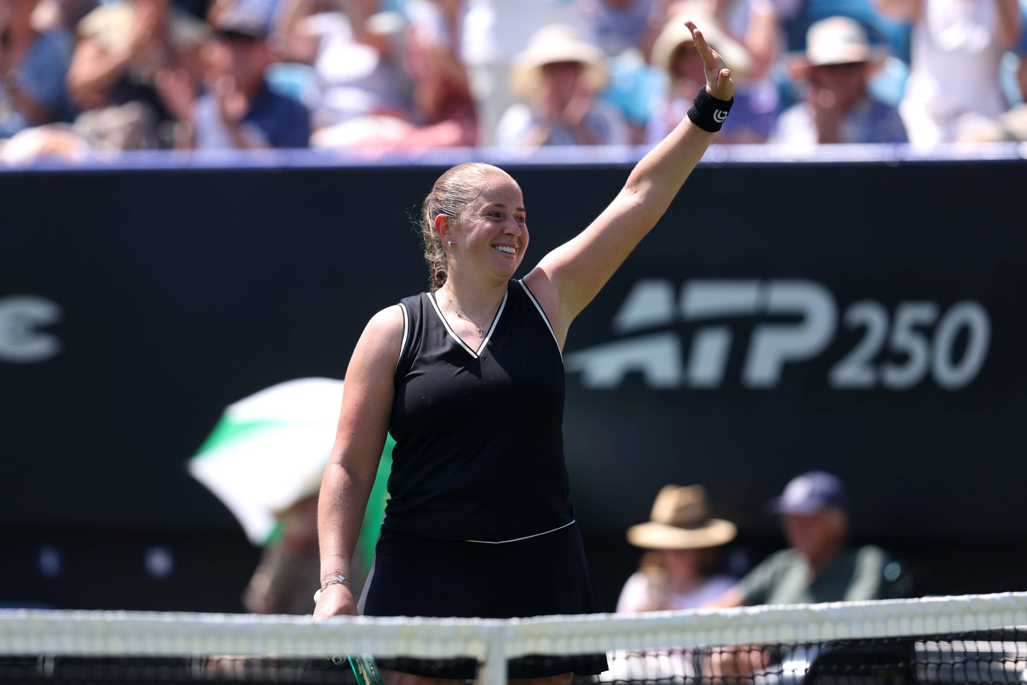 Jelena Ostapenko holding her hand up in the air and waving to the crowd at the Lexus Eastbourne Open