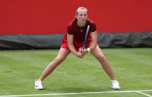 British tennis player Mika Stojsavljevic stood on a grass court while preparing to hit a return