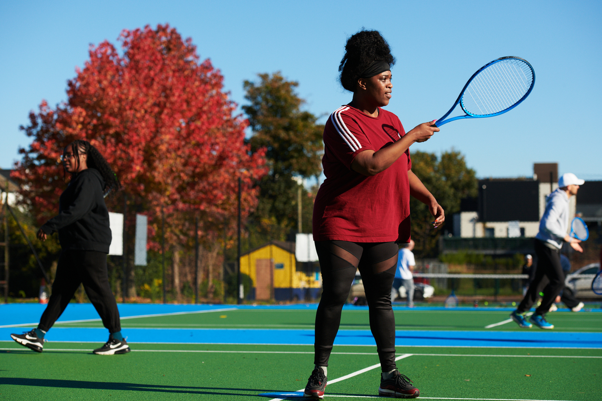 A woman hitting a ball at a Free Park Tennis Session
