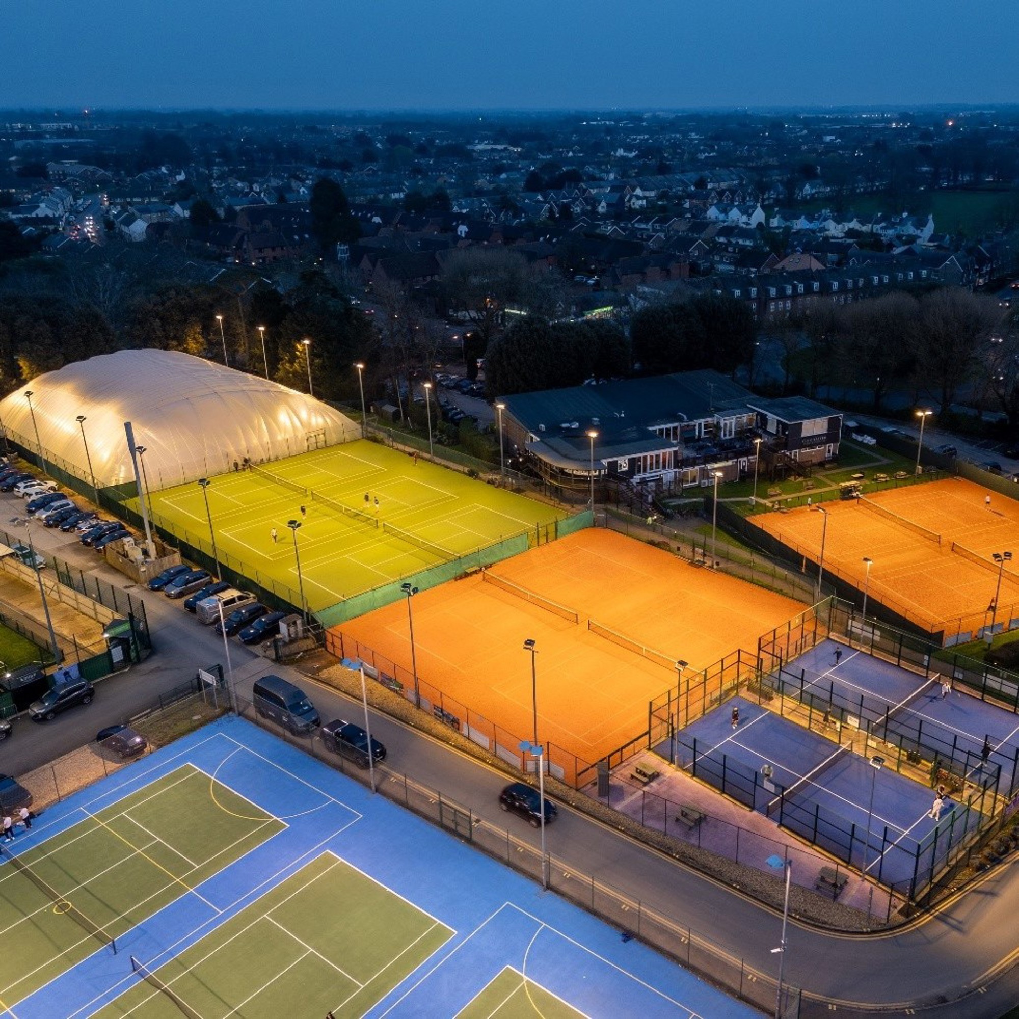 A bird's eye view of Chichester Racquets and Fitness Club courts lit up by floodlights
